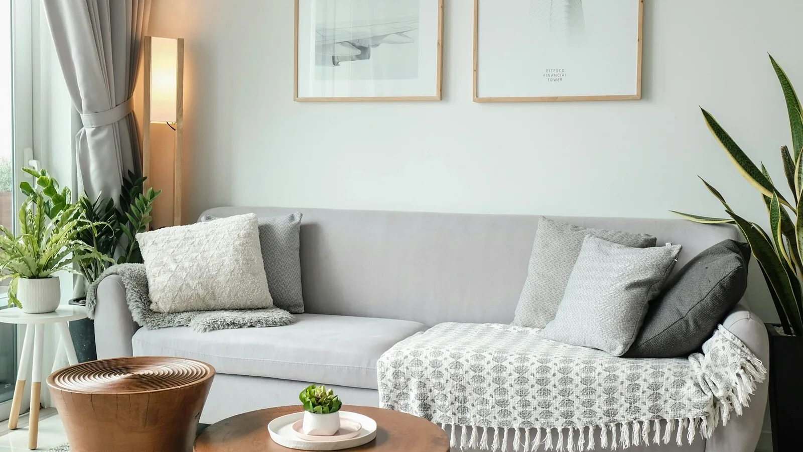 Helles, modernes Wohnzimmer mit Sofa, Sessel und Pflanzen